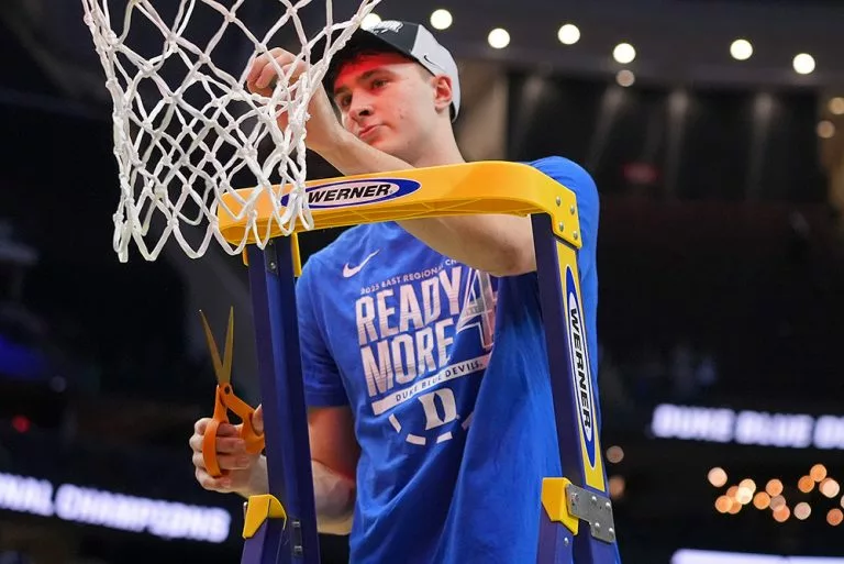 Player cutting down the net after NCAA championship win