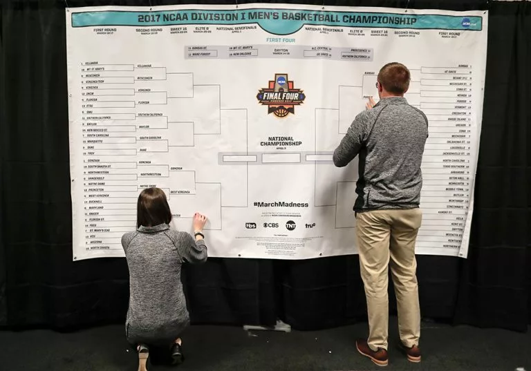 NCAA staff filling out the tournament bracket ahead of the Sweet 16